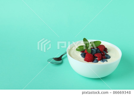 Concept of tasty breakfast with yogurt on mint background 86669348