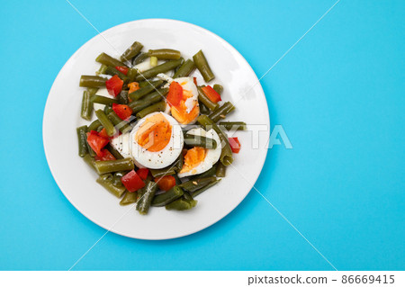 salad green beans, pepper and boiled eggs on plate 86669415
