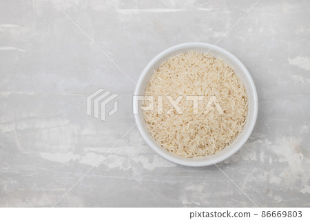 raw rice on white bowl on gray ceramic 86669803