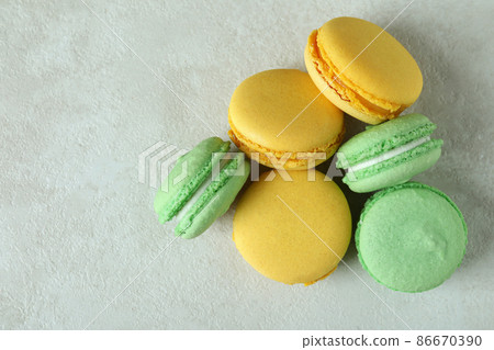 Concept of tasty dessert with macaroons on white textured background Concept of tasty dessert with macaroons on white textured background 86670390