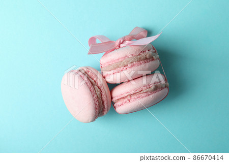Concept of tasty dessert with macaroons on blue background Concept of tasty dessert with macaroons on blue background 86670414