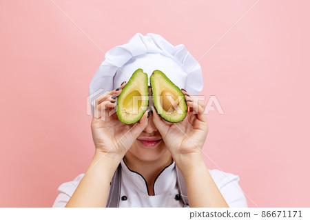Comic portrait of lady-cook, chef in white hat and kitchen apron isolated on pink background. Cuisine, profession, business, food, taste, restaurant concept. Comic portrait of lady-cook, chef in white hat and kitchen apron isolated on pink background. Cuisine, profession, business, food, taste, restaurant concept. 86671171