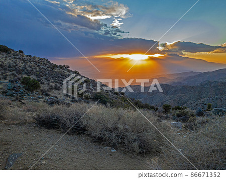 Image of a spectacular weather scene with impressive sun rays through a hole in the clouds Image of a spectacular weather scene with impressive sun rays through a hole in the clouds 86671352
