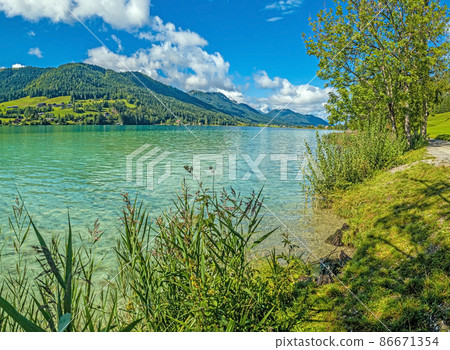 Panoramic view over turquoise lake Weissensee in Austrian province Carinthia during daytime Panoramic view over turquoise lake Weissensee in Austrian province Carinthia during daytime 86671354