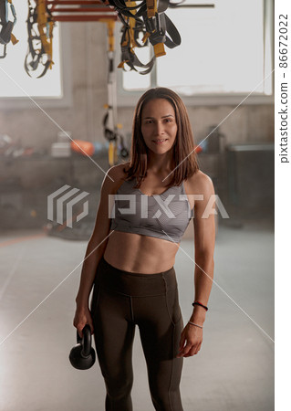 Athletic woman working with kettlebell in fitness club Athletic woman working with kettlebell in fitness club 86672022