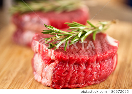 Raw Beef Tenderloin with Rosemary on a Cutting Board Raw Beef Tenderloin with Rosemary on a Cutting Board 86672035