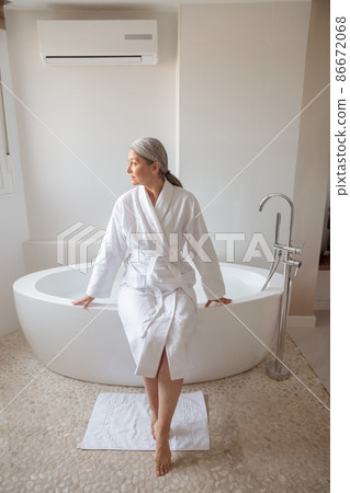 Beautiful lady getting ready to take bath 86672068
