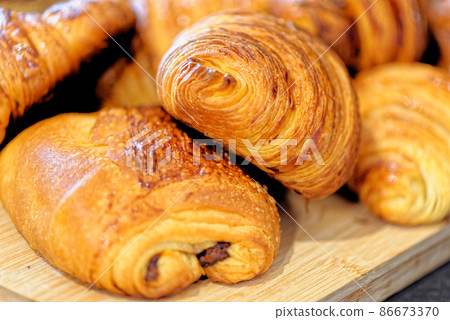 Fresh croissants and pain au chocolate on a plate Fresh croissants and pain au chocolate on a plate 86673370