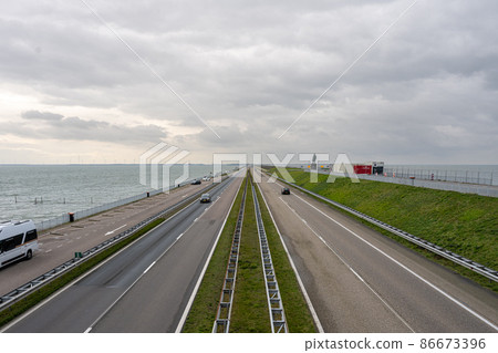 The Afsluitdijk is a major dam and causeway in the Netherlands. It is a fundamental part of the larger Zuiderzee Works, damming off salt water of the North Sea, and turning it into a fresh water lake 86673396