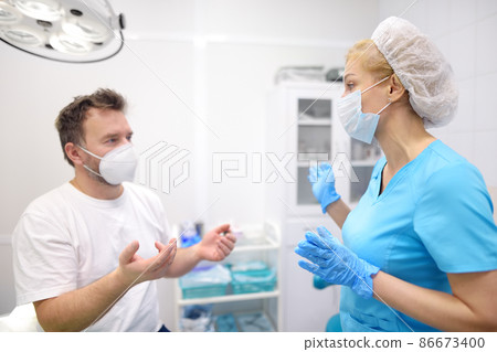 The patient on a surgeon doctor's appointment. The doctor appoint plan of treatment. Practitioner at work place in medical office at the clinic. 86673400