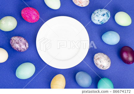 Festive Easter table setting with painted eggs on blue background. Space for text. Studio Photo Festive Easter table setting with painted eggs on blue background. Space for text. Studio Photo 86674172