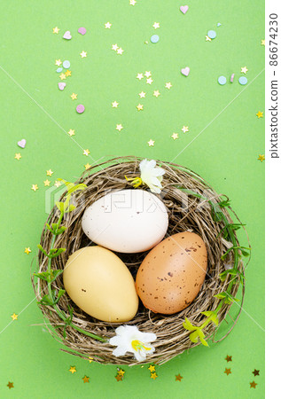 Top view of color easter haqndmade eggs and nest flatlay. Trendy minimal design spring background. Space for text. Stuio Photo Top view of color easter haqndmade eggs and nest flatlay. Trendy minimal design spring background. Space for text. Stuio Photo 86674230