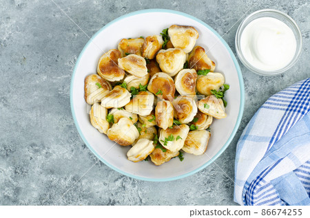 Blue bowl with fried dumplings. Studio Photo 86674255