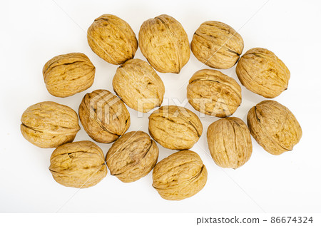 Unpeeled ripe walnuts on white background. Studio Photo Unpeeled ripe walnuts on white background. Studio Photo 86674324