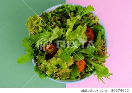 Bowl of mixed salad on bright, color background. 86674632