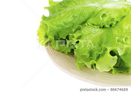 Green lettuce leaves on wooden plate. Green lettuce leaves on wooden plate. 86674689