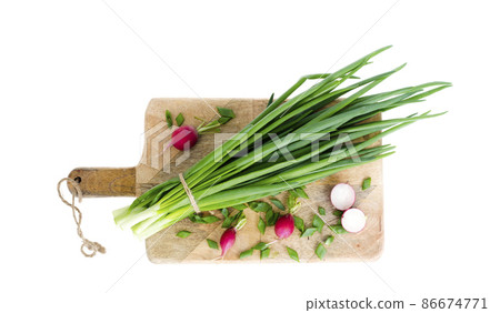 Fresh green onions, red radish on cutting board. Fresh green onions, red radish on cutting board. 86674771
