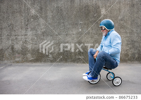 Funny businessman driving retro trike outdoor 86675233