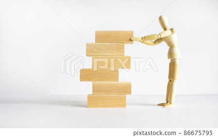 Symbol of building success foundation. Businessman model put wooden blocks on the stack of wooden blocks. Beautiful white background, copy space. Business, building success foundation concept. Symbol of building success foundation. Businessman model put wooden blocks on the stack of wooden blocks. Beautiful white background, copy space. Business, building success foundation concept. 86675795