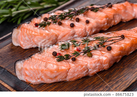 Grilled salmon with herbs served on black concrete table 86675823