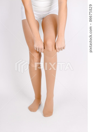 Medical Compression Stockings for varicose veins and venouse therapy. Compression Hosiery. Sock for sports isolated on white background. Beige color socks mock up for advertising, branding, design. 86675829