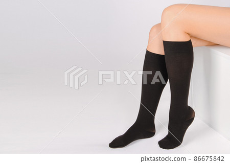 Medical Compression Stockings for varicose veins and venouse therapy. Compression Hosiery. Sock for sports isolated on white background. Black color socks mock up for advertising, branding, design. 86675842