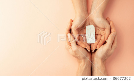 Pregnancy test kit. Female hand hold positive pregnant test with silk ribbon on pink banner background. Medical healthcare gynecological, pregnancy fertility maternity people concept. 86677202