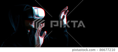 Vr glasses virtual reality. Blured young man in digital headset for virtual reality technology on dark background with glitch effect. Amazing technology, online game, entertainment. 86677210