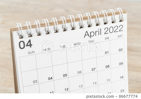 April 2022 desk calendar on wooden background. 86677774