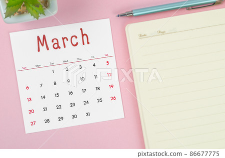 March 2022 calendar with note book on pink background. 86677775