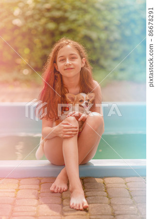 Vacation with a pet. Cute girl 10 or 11 years old with her dog by the pool. Vacation with a pet. Cute girl 10 or 11 years old with her dog by the pool. 86678291
