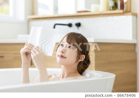 A woman who enjoys reading while soaking in the bath A woman who enjoys reading while soaking in the bath 86678406