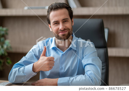 A man sitting in the office and looking contented A man sitting in the office and looking contented 86678527
