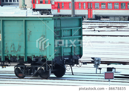 Train carriage standing on dark rails on snow in winter with trains on background 86678835