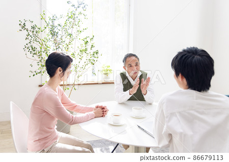 Senior couple enjoying conversation with an adult child Senior couple enjoying conversation with an adult child 86679113