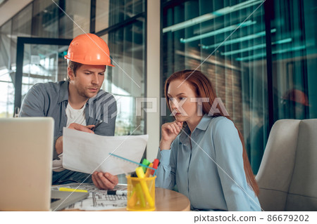Man and woman carefully looking at document Man and woman carefully looking at document 86679202