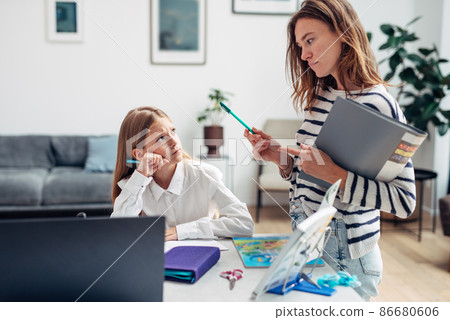 Mother controls her daughter to learn her lessons Mother controls her daughter to learn her lessons 86680606