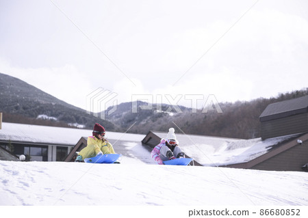 Elementary school girl playing in the snow on the ski slopes 86680852