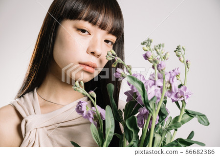 一個二十多歲的女人帶著鮮花的自然美形象 一個二十多歲的女人帶著鮮花的自然美形象 86682386