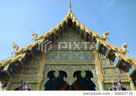 Art eaves decorated with gilded gold at Rong Suea Ten Temple, a famous attraction in Chiang Rai, Thailand 86683716