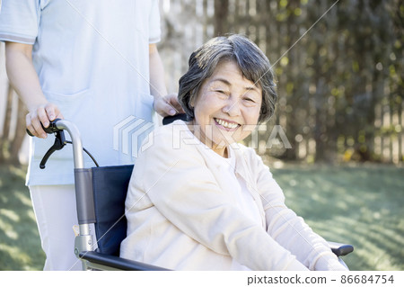 護理形象:坐輪椅的老年婦女和女性護理人員 護理形象:坐輪椅的老年婦女和女性護理人員 86684754