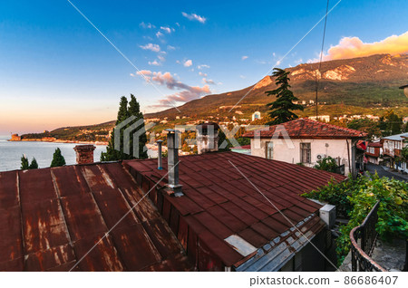 beautiful street with stone historical houses and paving stones against the backdrop of mountains 86686407