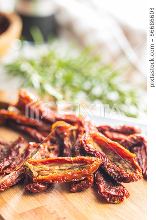 Sun dried tomatoes on cutting board. Sun dried tomatoes on cutting board. 86686603