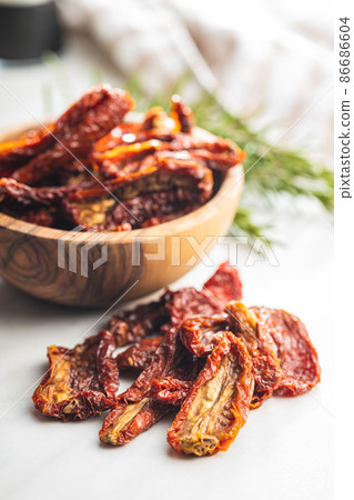Sun dried tomatoes on white table. Sun dried tomatoes on white table. 86686604