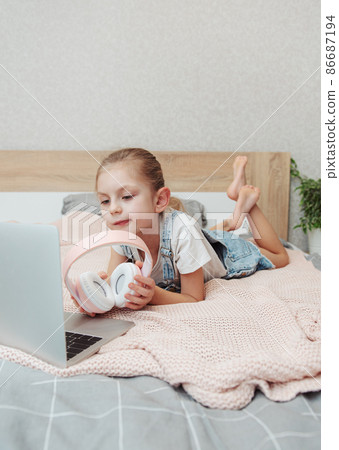 Little girl learning online with laptop computer at bedroom. Little girl learning online with laptop computer at bedroom. 86687194