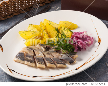 herring with potatoes and pickled onions on a white plate herring with potatoes and pickled onions on a white plate 86687241