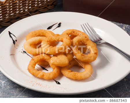 onion rings on a white plate. Concept onion rings on a white plate. Concept 86687343