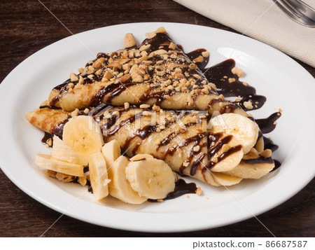 sweet pancake with banana and chocolate sauce sweet pancake with banana and chocolate sauce 86687587