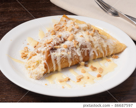 pancake with condensed milk nuts and coconut shavings pancake with condensed milk nuts and coconut shavings 86687597