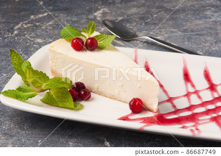 classic cheesecake decorated with berries, mint and berry sauce 86687749